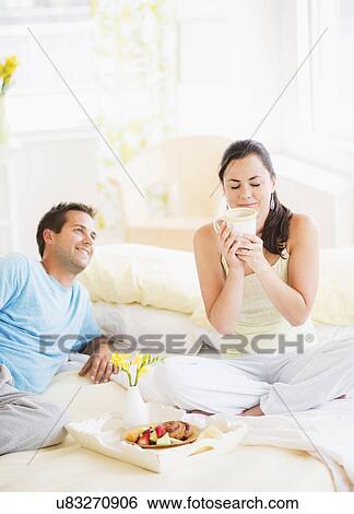 Stock Photograph - Woman and man having breakfast in bed. Fotosearch
