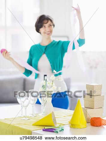 Stock Photo - Woman decorating room for party. Fotosearch