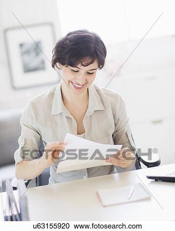 Woman doing paperwork at home office View Large Photo Image Stock Image - Woman doing paperwork at home office. Fotosearch
