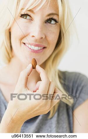 Woman eating candy cane, studio shot View Large Photo Image Stock Image - Woman eating candy cane, studio shot. Fotosearch