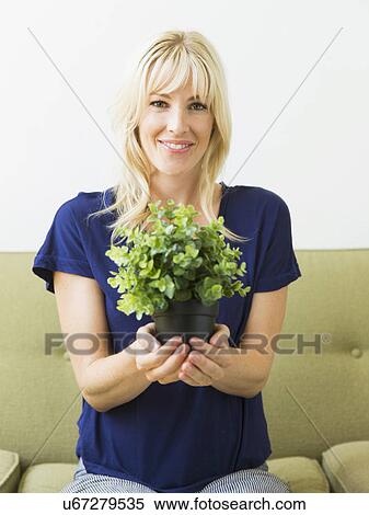Stock Photography - Woman holding potted plant. Fotosearch