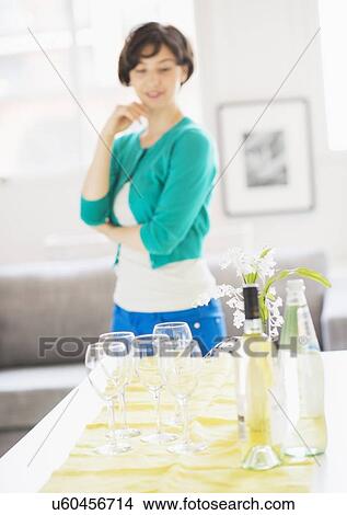 Woman standing behind table at home View Large Photo Image Picture - Woman standing behind table at home. Fotosearch