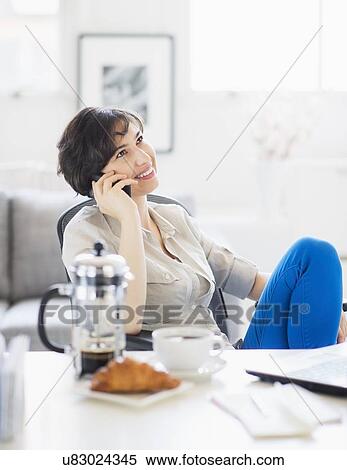Woman talking on phone at home office View Large Photo Image Stock Photography - Woman talking on phone at home office. Fotosearch