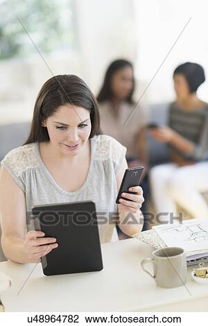 Woman using digital tablet and mobile phone View Large Photo Image Stock Image - Woman using digital tablet and mobile phone. Fotosearch