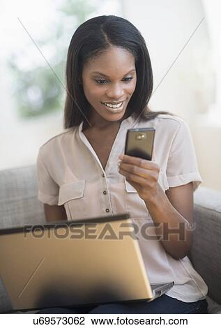 Woman using laptop and mobile phone View Large Photo Image Stock Image - Woman using laptop and mobile phone. Fotosearch
