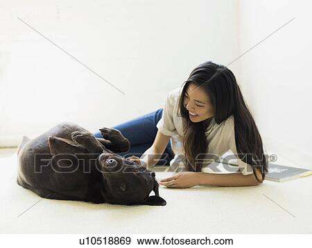Stock Photo - Woman with dog lying on floor. Fotosearch