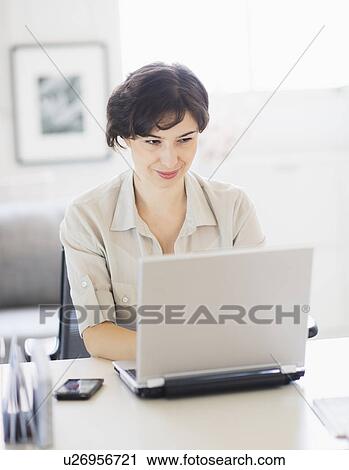 Woman working on laptop at home office View Large Photo Image Stock Image - Woman working on laptop at home office. Fotosearch