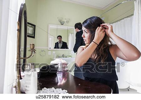 Stock Image - Young couple getting ready for party. Fotosearch