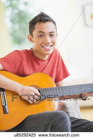 Young man playing guitar View Large Photo Image Stock Photography - Young man playing guitar. Fotosearch