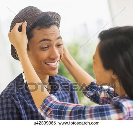 Young man trying on hat View Large Photo Image Stock Photography - Young man trying on hat. Fotosearch