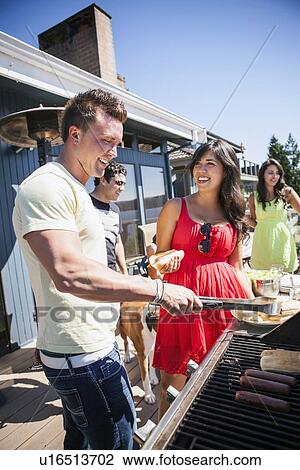 Young people enjoying barbecue View Large Photo Image Stock Image - Young people enjoying barbecue. Fotosearch