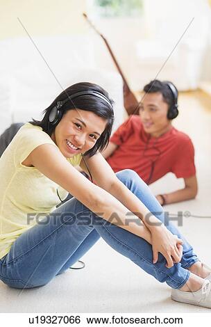Young woman and man listening music with headphones on View Large Photo Image Stock Photograph - Young woman and man listening music with headphones on. Fotosearch