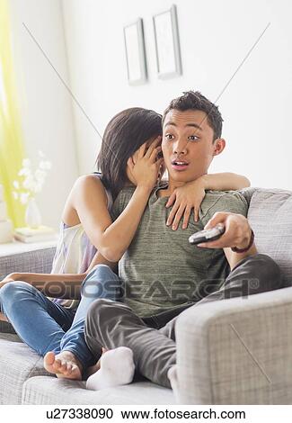 Young woman and young man sitting on sofa View Large Photo Image Stock Image - Young woman and young man sitting on sofa. Fotosearch