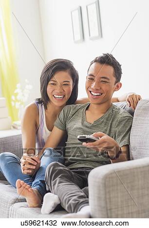 Young woman and young man sitting on sofa View Large Photo Image Stock Image - Young woman and young man sitting on sofa. Fotosearch