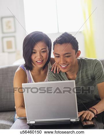 Young woman and young man using laptop View Large Photo Image Stock Image - Young woman and young man using laptop. Fotosearch