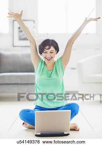 Young woman cheering in front of laptop View Large Photo Image Stock Photo - Young woman cheering in front of laptop. Fotosearch
