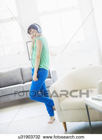 Young woman listening to music at home View Large Photo Image Stock Image - Young woman listening to music at home. Fotosearch