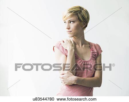 Stock Image - Young woman looking away, studio shot. Fotosearch