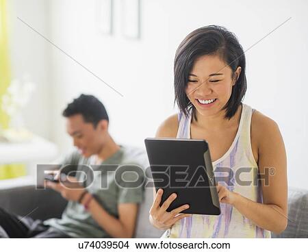 Young woman using digital tablet View Large Photo Image Picture - Young woman using digital tablet. Fotosearch