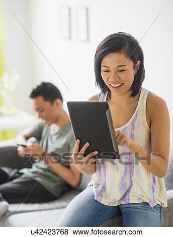 Stock Photo - Young woman using digital tablet. Fotosearch