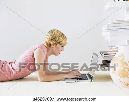 Young woman using laptop, studio shot View Large Photo Image Stock Photo - Young woman using laptop, studio shot. Fotosearch