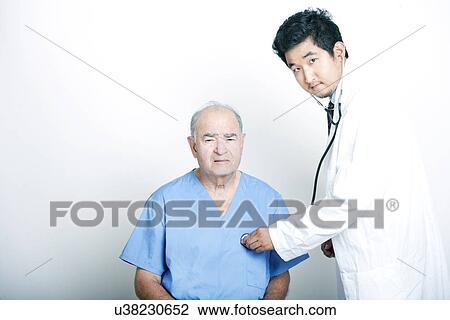 A young Asian Doctor comforting a Senior adult patient View Large Photo Image Stock Image - A young Asian Doctor comforting a Senior adult patient. Fotosearch