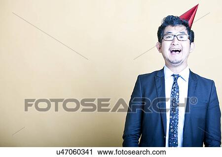 Asian business man wearing party hat View Large Photo Image Stock Image - Asian business man wearing party hat. Fotosearch