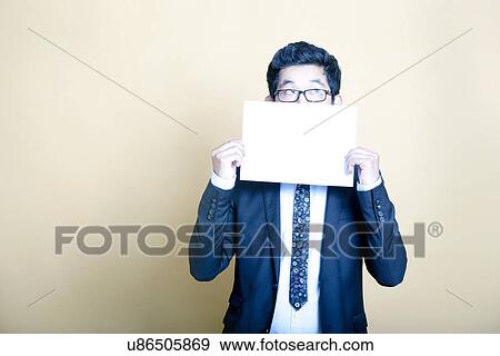 Asian businessman holding white blank sign View Large Photo Image Stock Photo - Asian businessman holding white blank sign. Fotosearch