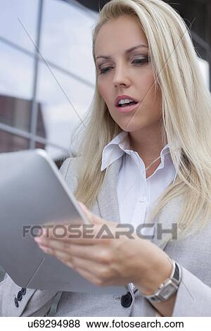 Beautiful businesswoman using digital tablet outdoors View Large Photo Image Stock Photo - Beautiful businesswoman using digital tablet outdoors. Fotosearch