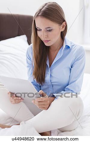 Beautiful woman using tablet computer on her bed View Large Photo Image Stock Image - Beautiful woman using tablet computer on her bed. Fotosearch