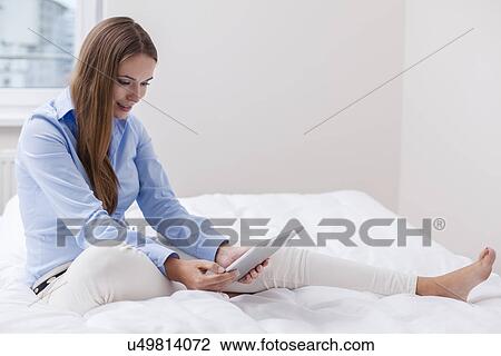 Beautiful woman using tablet computer on her bed View Large Photo Image Stock Image - Beautiful woman using tablet computer on her bed. Fotosearch