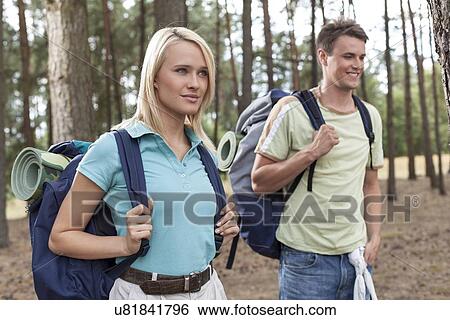 Beautiful young woman with man trekking in forest View Large Photo Image Stock Photograph - Beautiful young woman with man trekking in forest. Fotosearch