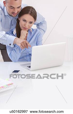 Businessman and businesswoman working together on a computer View Large Photo Image Stock Photo - Businessman and businesswoman working together on a computer . Fotosearch