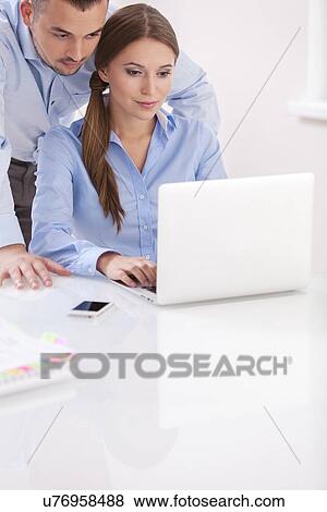Stock Photo - Businessman and businesswoman working together on a computer . Fotosearch