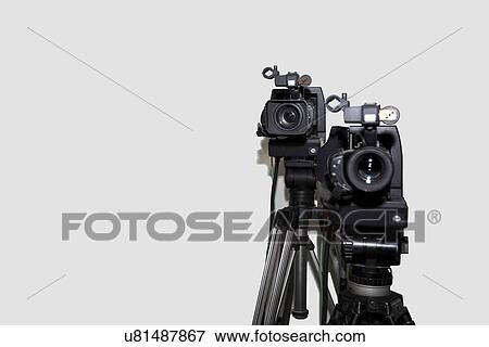 Stock Photo - Camera and tripod against white background. Fotosearch