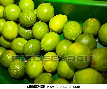 Stock Photo - Close-up of green lemons on display in grocery store. Fotosearch