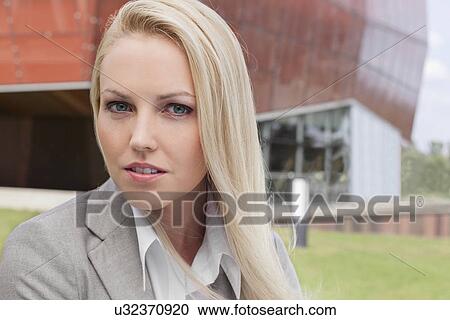 Close-up portrait of young businesswoman against office building View Large Photo Image Stock Image - Close-up portrait of young businesswoman against office building. Fotosearch
