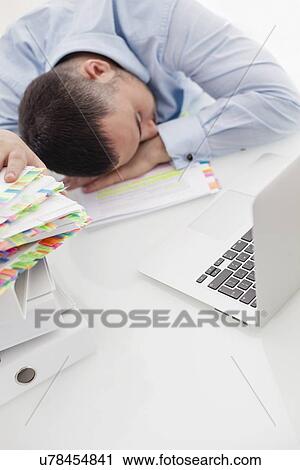 Close-up view of Caucasian businessman asleep at his desk View Large Photo Image Stock Image - Close-up view of Caucasian businessman asleep at his desk. Fotosearch