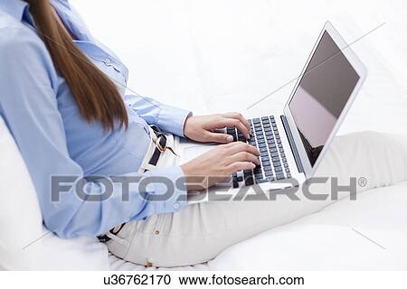 Stock Image - Close-up view of hands using laptop. Fotosearch