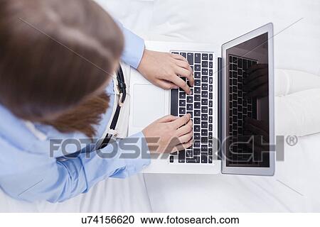 Stock Image - Close-up view of hands using laptop. Fotosearch