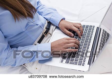 Close-up view of hands using laptop View Large Photo Image Stock Photo - Close-up view of hands using laptop. Fotosearch