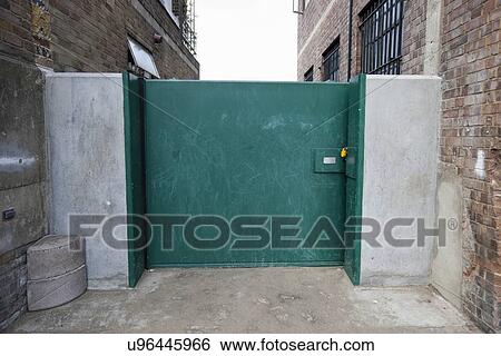 Closed green gate connected to buildings View Large Photo Image Stock Photograph - Closed green gate connected to buildings. Fotosearch