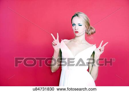 Stock Image - Cool woman wearing white dress on red background. Fotosearch