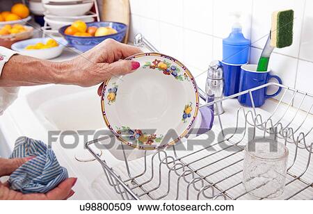 Cropped image of senior woman arranging plate in rack at kitchen counter View Large Photo Image Stock Photo - Cropped image of senior woman arranging plate in rack at kitchen counter. Fotosearch