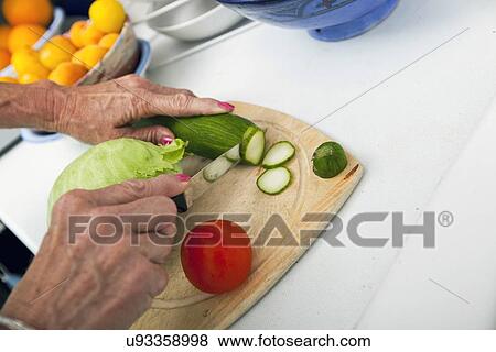 Cropped image of senior woman cutting vegetables on chopping board in kitchen View Large Photo Image Stock Photo - Cropped image of senior woman cutting vegetables on chopping board in kitchen. Fotosearch