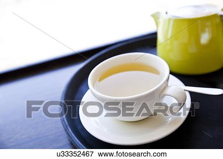 Cup of Green Tea on a tray with saucer and spoon View Large Photo Image Stock Photo - Cup of Green Tea on a tray with saucer and spoon. Fotosearch