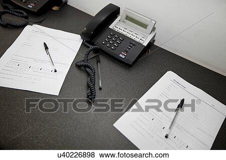 Stock Photo - Documents and landline telephones on table. Fotosearch