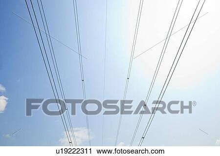 Stock Image - Electrical Power lines against clear Skype. Fotosearch