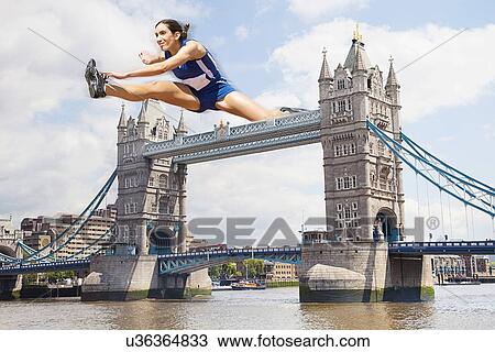 Stock Image - Female Athlete hurdling Tower Bridge. Fotosearch