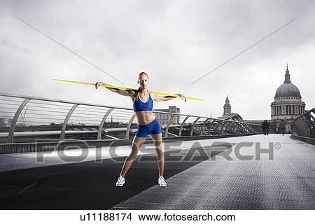 Picture - Female Athlete with javelin standing in front of St Paul's Cathedral in London. Fotosearch